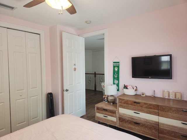 bedroom featuring a closet, dark hardwood / wood-style floors, and ceiling fan