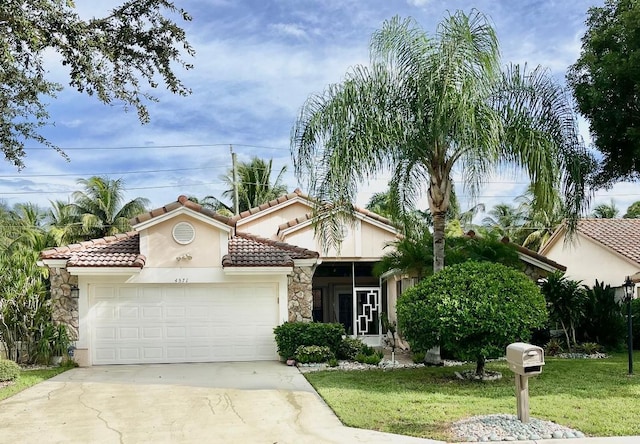 mediterranean / spanish home with a garage and a front lawn