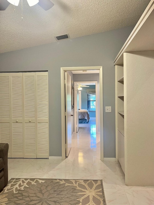 interior space featuring a textured ceiling and vaulted ceiling