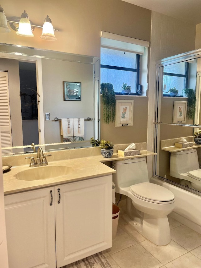 full bathroom featuring vanity, enclosed tub / shower combo, tile patterned floors, and toilet