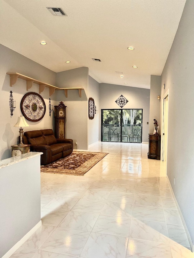 corridor with lofted ceiling and a textured ceiling