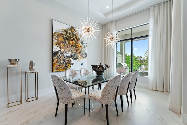 dining room with a tray ceiling and a notable chandelier