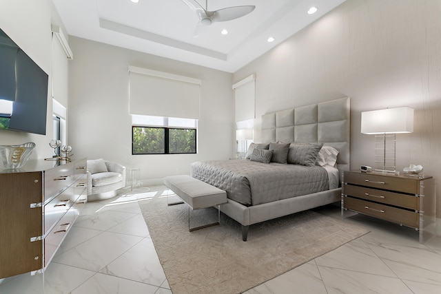 bedroom featuring ceiling fan, a tray ceiling, and a towering ceiling