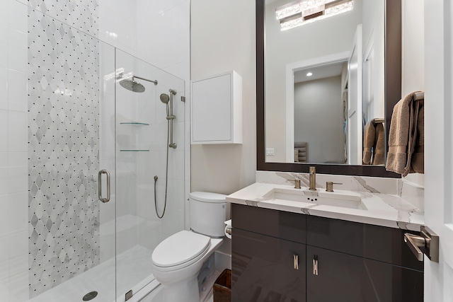 bathroom with a shower with shower door, vanity, and toilet