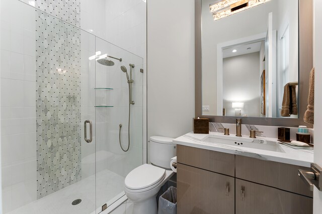 bathroom featuring vanity, toilet, and an enclosed shower