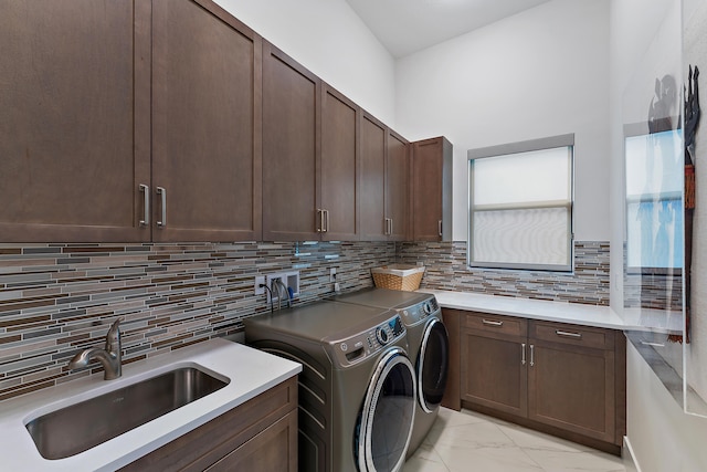 washroom featuring cabinets, washer and clothes dryer, and sink