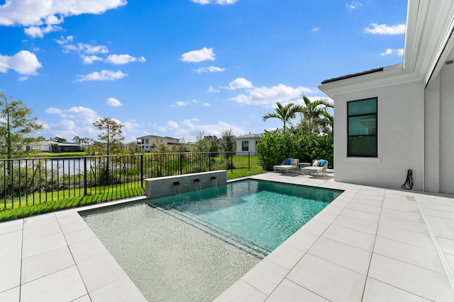 view of pool with pool water feature, a water view, a patio area, and a yard