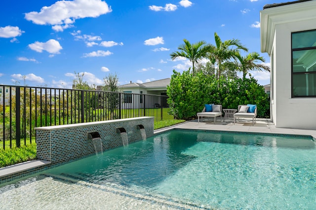 view of swimming pool with pool water feature and a patio area