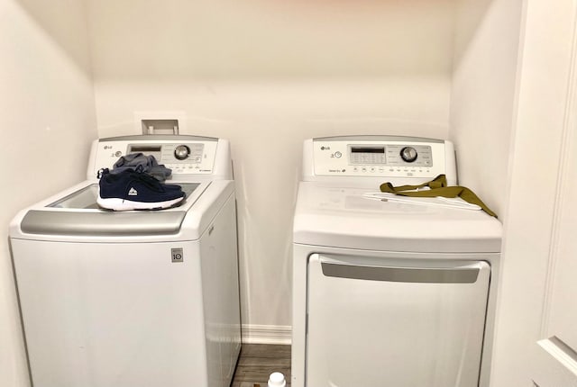 washroom with wood-type flooring and washer and dryer