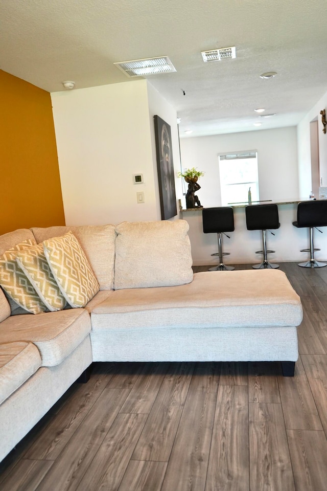 living room featuring a textured ceiling and dark hardwood / wood-style flooring