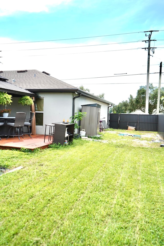 view of yard featuring a storage unit and a wooden deck