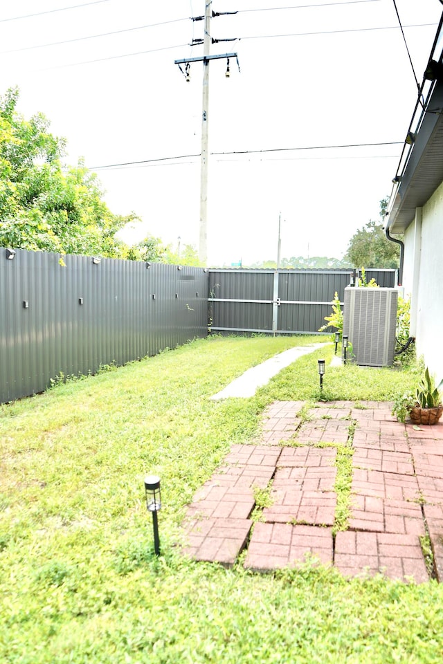 view of yard with central AC unit and a patio area