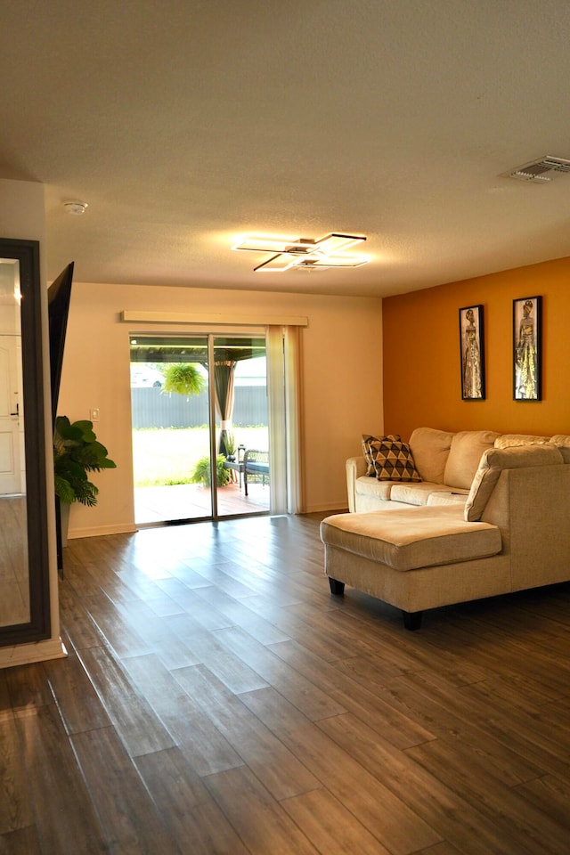 living room featuring a textured ceiling and dark hardwood / wood-style flooring