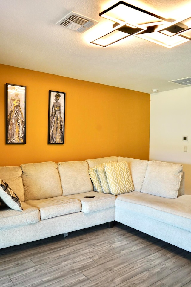 living room with a textured ceiling and hardwood / wood-style flooring