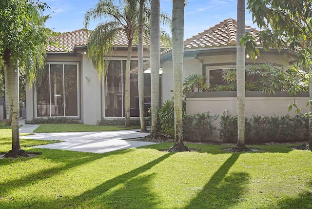 6595 NW 32nd Ter, Boca Raton, FL 33496 - rear view of house with stucco siding, a tiled roof, and a lawn