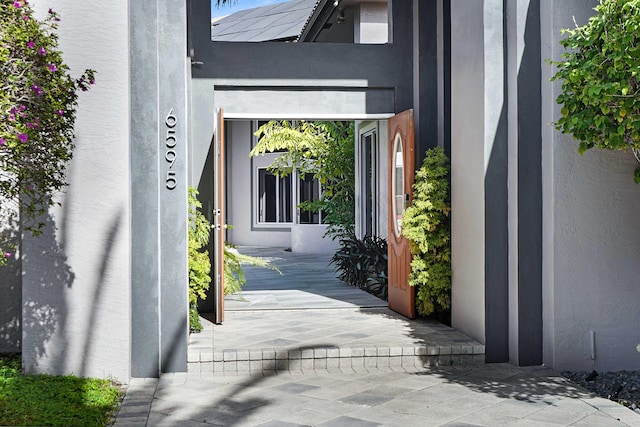 6595 NW 32nd Ter, Boca Raton, FL 33496 - view of exterior entry featuring stucco siding and roof mounted solar panels