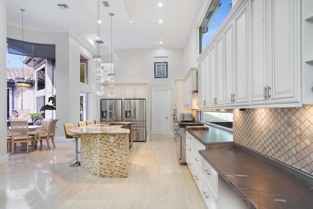 6595 NW 32nd Ter, Boca Raton, FL 33496 - kitchen with a high ceiling, stainless steel appliances, pendant lighting, a kitchen breakfast bar, and a kitchen island with sink