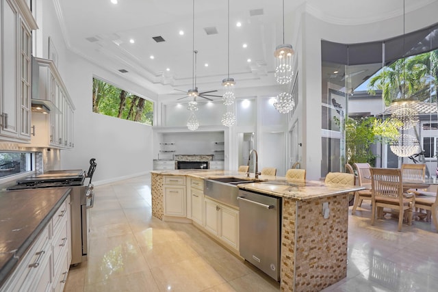 6595 NW 32nd Ter, Boca Raton, FL 33496 - kitchen featuring appliances with stainless steel finishes, cream cabinets, a sink, a high ceiling, and a fireplace