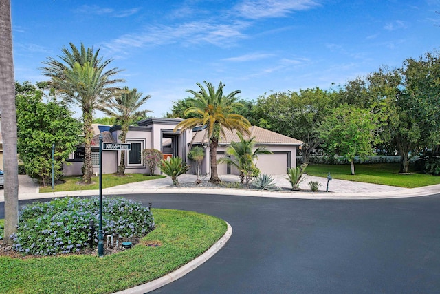 6595 NW 32nd Ter, Boca Raton, FL 33496 - view of front facade with curved driveway, stucco siding, a garage, and a front yard