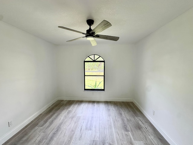 spare room featuring a textured ceiling, light hardwood / wood-style floors, and ceiling fan