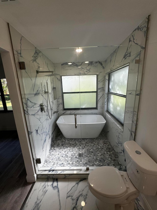 bathroom featuring plenty of natural light, toilet, and independent shower and bath