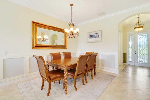 dining area with crown molding, an inviting chandelier, and light tile patterned floors