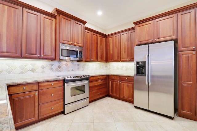 kitchen featuring decorative backsplash, light stone countertops, light tile patterned floors, stainless steel appliances, and crown molding