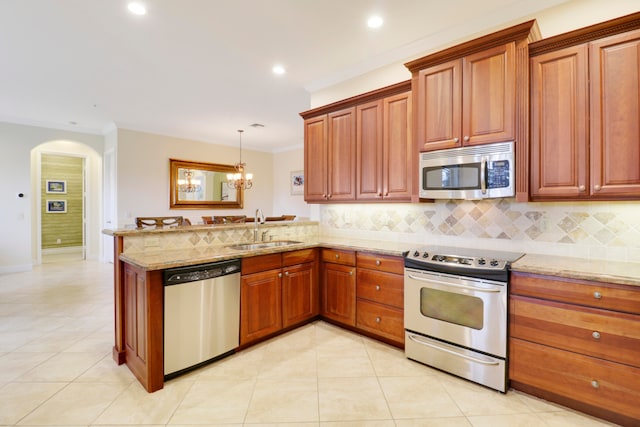 kitchen featuring stainless steel appliances, sink, kitchen peninsula, and tasteful backsplash