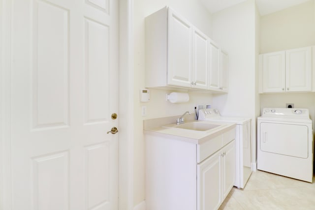 washroom with cabinets, washer and dryer, light tile patterned floors, and sink