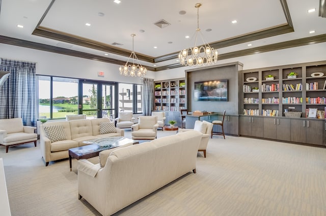 carpeted living room featuring crown molding, a tray ceiling, and a chandelier