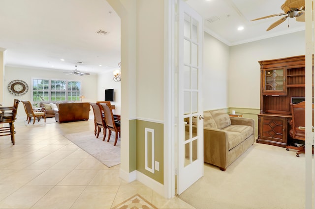 interior space with ceiling fan with notable chandelier, light tile patterned floors, and crown molding