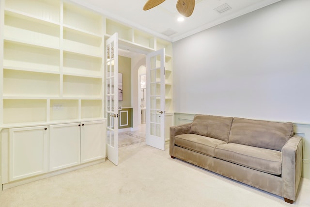 sitting room featuring light carpet, ceiling fan, ornamental molding, and french doors