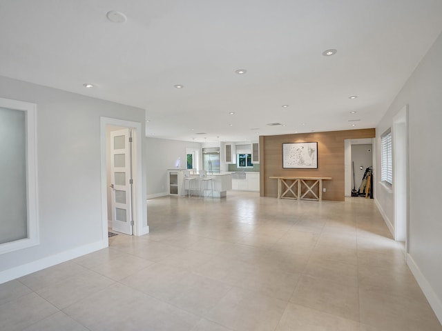 unfurnished living room featuring light tile patterned flooring and a healthy amount of sunlight