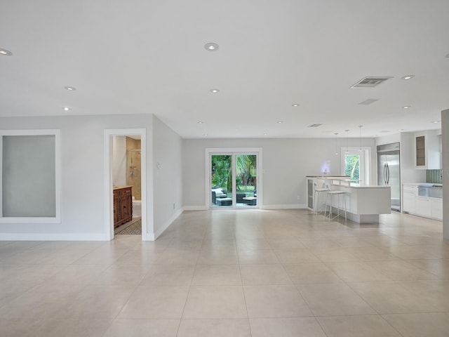 unfurnished living room with a healthy amount of sunlight and light tile patterned floors