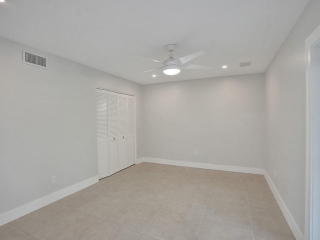 tiled spare room with ceiling fan