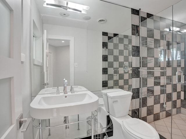 bathroom with tile walls, tile patterned flooring, toilet, and a shower with door