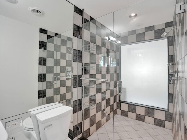 bathroom featuring tile walls, toilet, and an enclosed shower