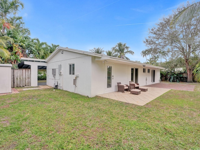 rear view of house featuring a patio and a lawn