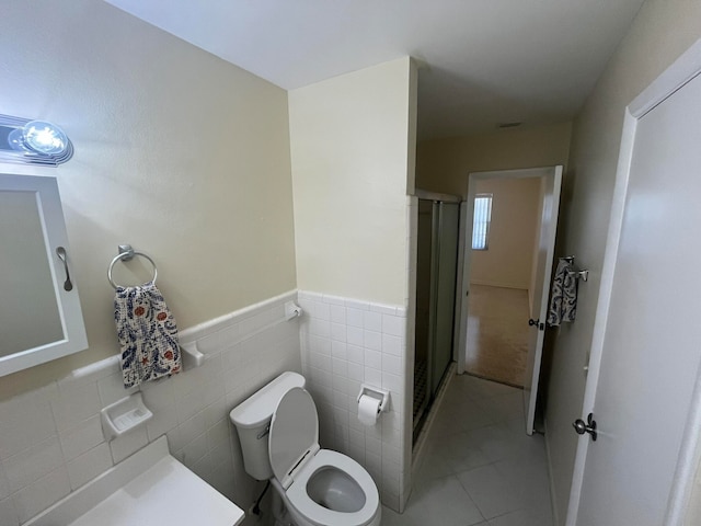 bathroom featuring tile walls, tile patterned flooring, toilet, and an enclosed shower