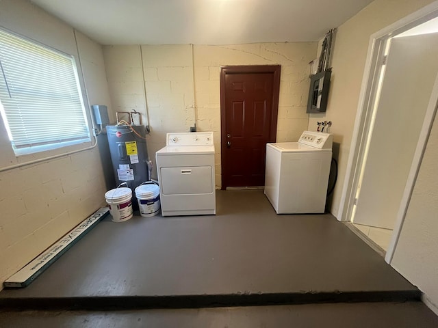 clothes washing area featuring water heater, electric panel, and washer and dryer