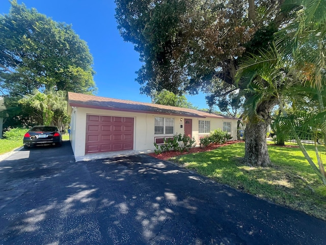 single story home featuring a garage and a front lawn