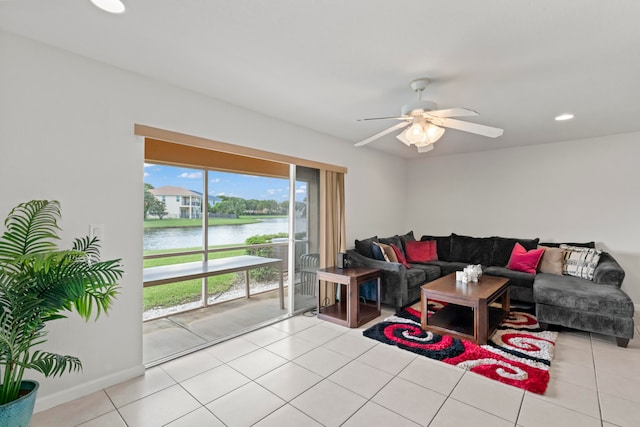 living room featuring a water view, ceiling fan, and light tile patterned flooring