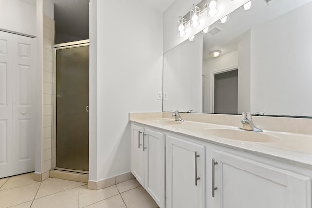 bathroom featuring tile patterned flooring, a shower with door, and vanity