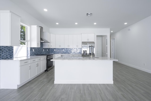 kitchen with light wood-type flooring, white cabinetry, stainless steel appliances, and a kitchen island with sink