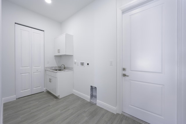 laundry area with electric dryer hookup, cabinets, sink, washer hookup, and light wood-type flooring