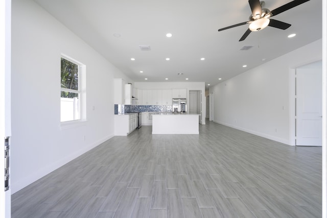 unfurnished living room featuring ceiling fan and light hardwood / wood-style flooring