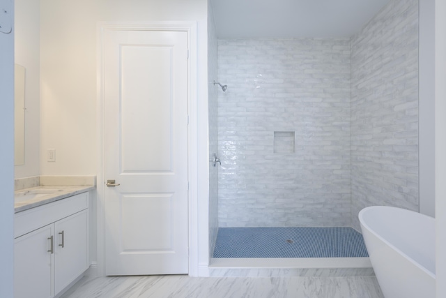 bathroom featuring a tile shower and vanity