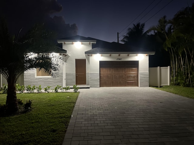 view of front of home featuring a garage and a yard