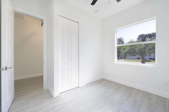 unfurnished bedroom with ceiling fan, a closet, and light hardwood / wood-style flooring