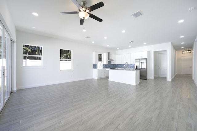 interior space with ceiling fan, light hardwood / wood-style flooring, and sink